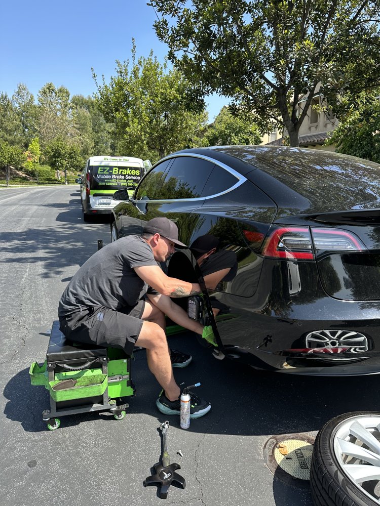 Black Tesla during mobile brake service on an Irvine street