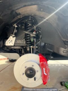 Close-up of a freshly serviced brake rotor and red caliper