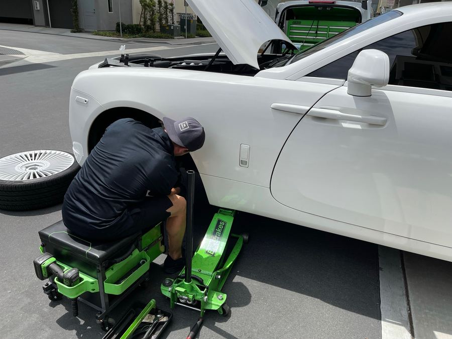 EZ-Brakes technician servicing a Rolls-Royce wheel with the van parked nearby
