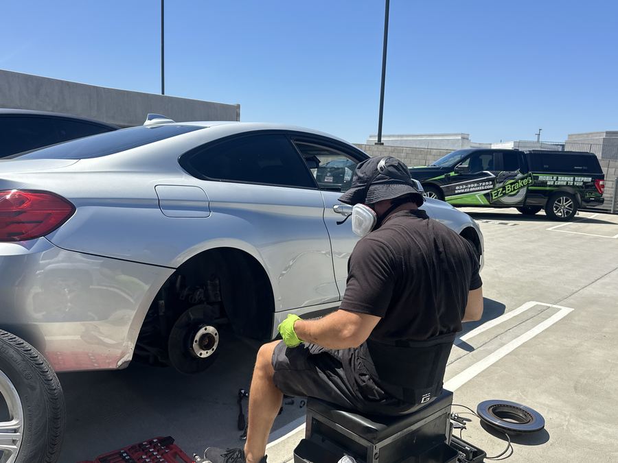 EZ-Brakes truck parked next to a white Jaguar F-Pace during a mobile brake job