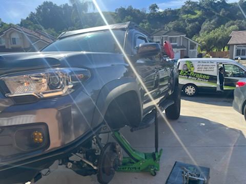 Mobile brake service on a truck in a driveway next to the EZ-Brakes van