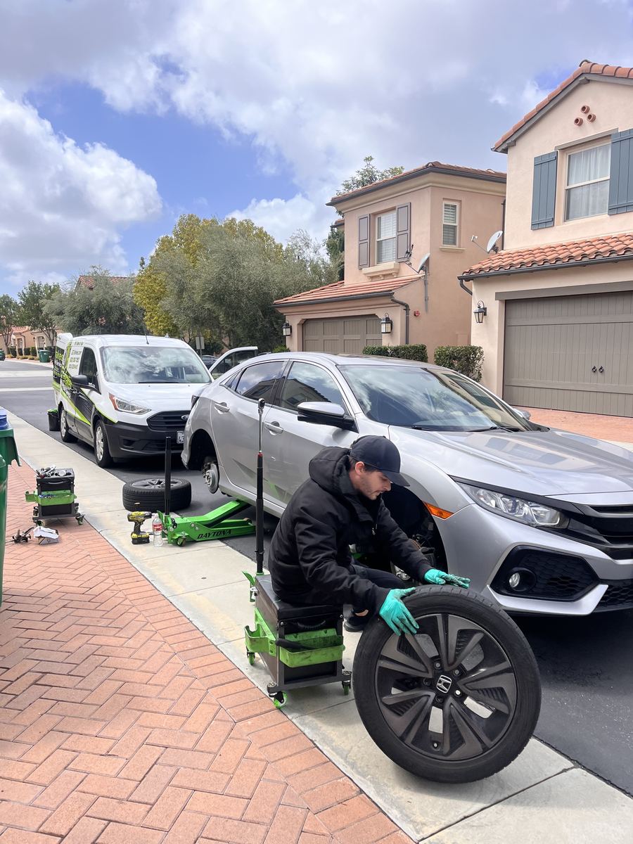Mobile brake technician servicing a Honda Civic curbside