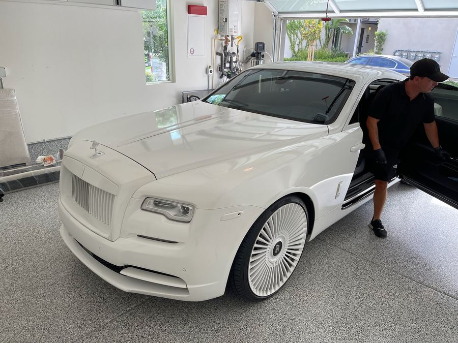 Mobile brake technician working on a Rolls-Royce in a home garage
