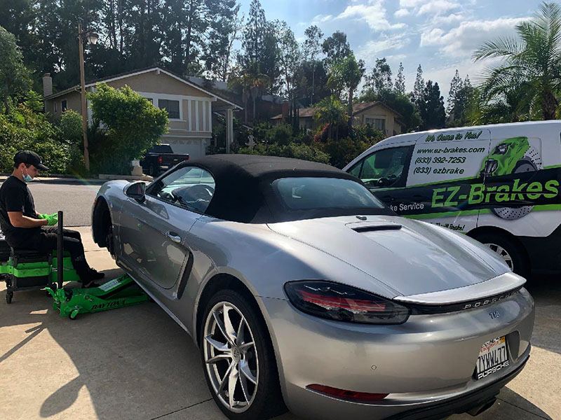 Porsche Boxster on a jack stand during mobile brake service with the EZ-Brakes van