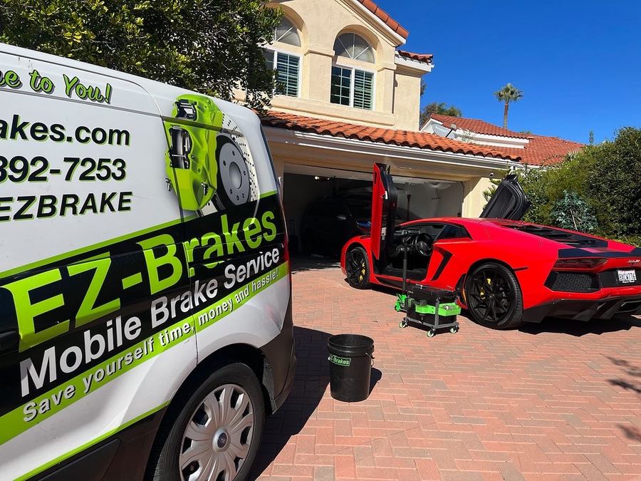 Red Lamborghini Aventador with doors open next to the EZ-Brakes van