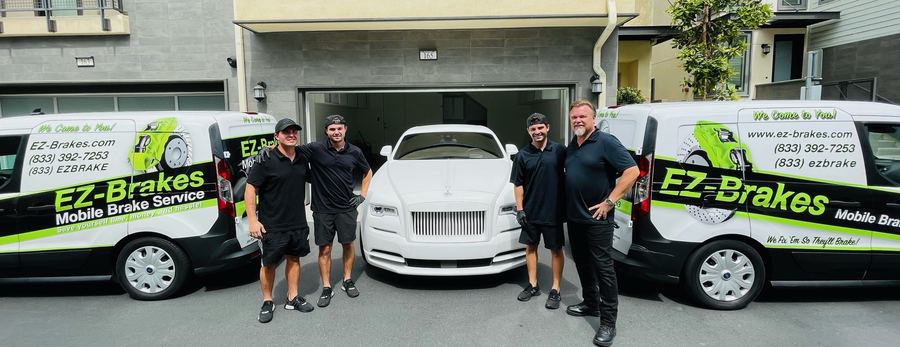 The EZ-Brakes team standing with a Rolls-Royce Wraith between two service vans