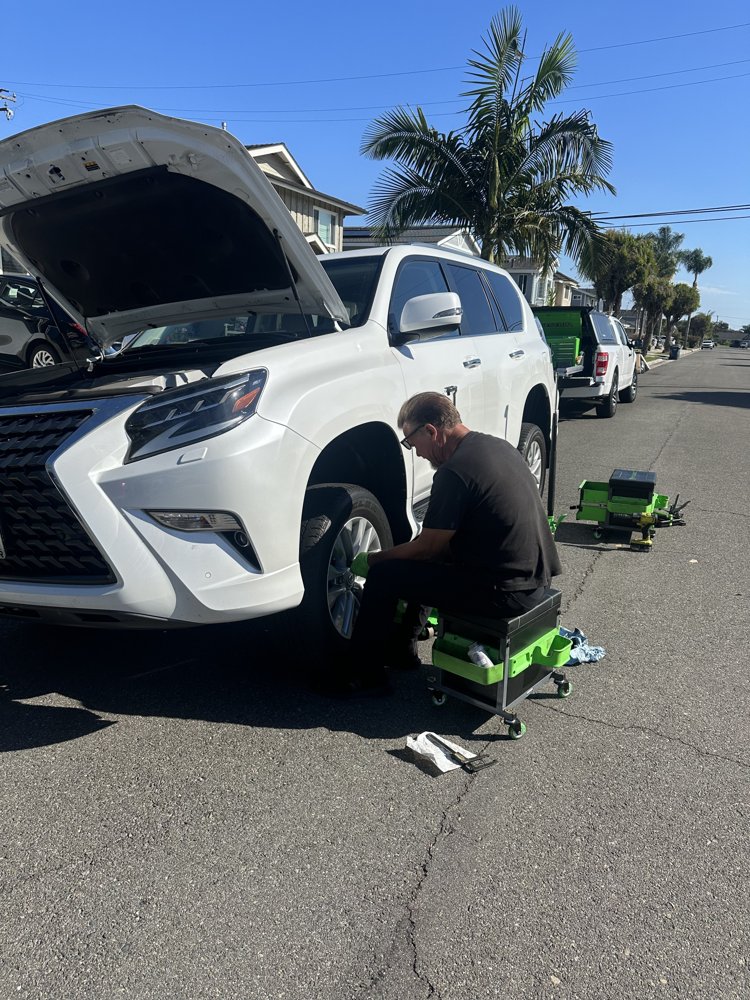 White Lexus GX during mobile brake service on a Huntington Beach street