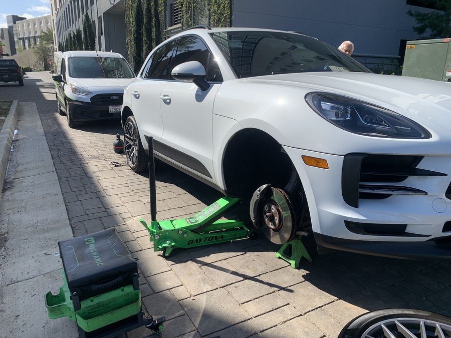 White Porsche Macan raised on a jack for mobile brake service